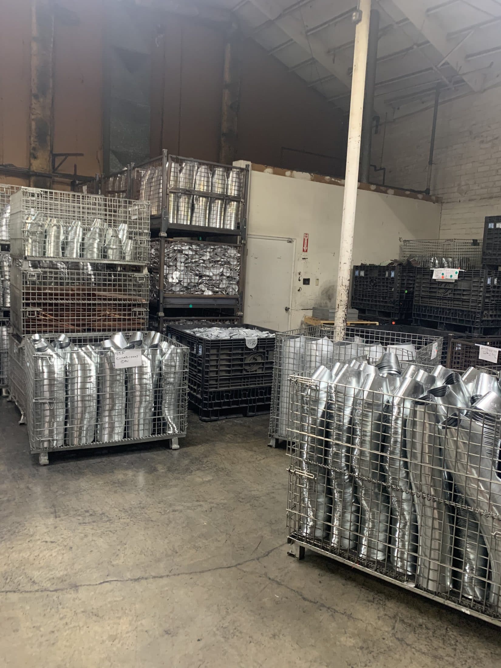 Wire baskets of formed metal parts staged on a storeroom floor